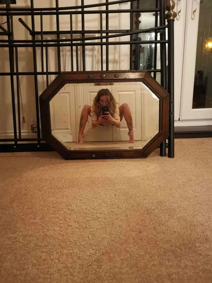 Funny mirror pics showing a woman crouching in front of a mirror on the floor