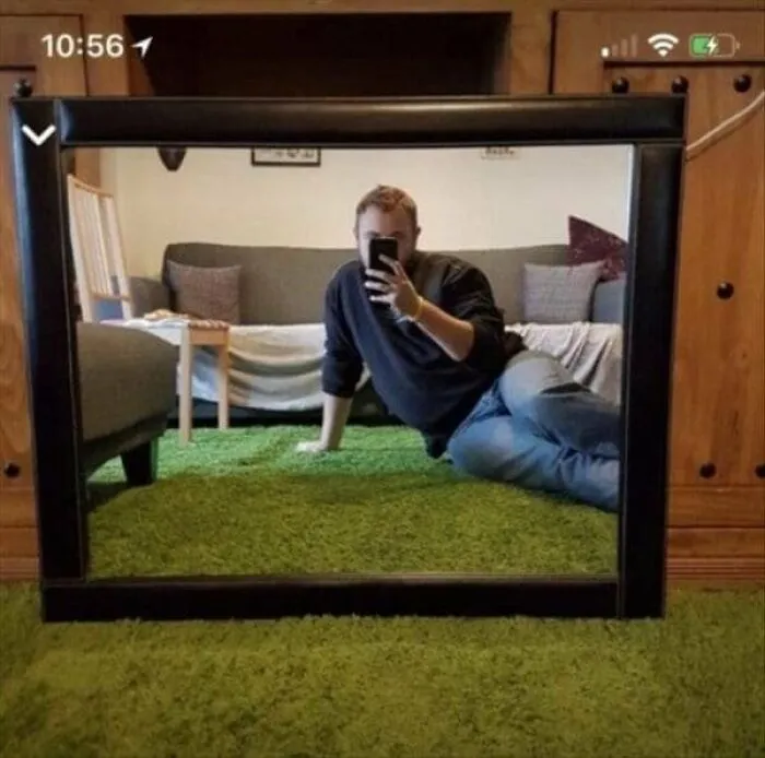 Funny mirror pics of a man posing dramatically on a green rug in a mirror reflection selfie