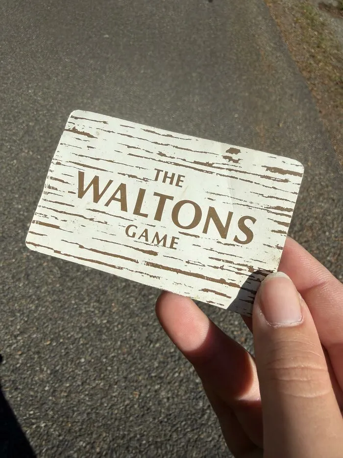 A person holding a game card outdoors as an example of a found paper item.