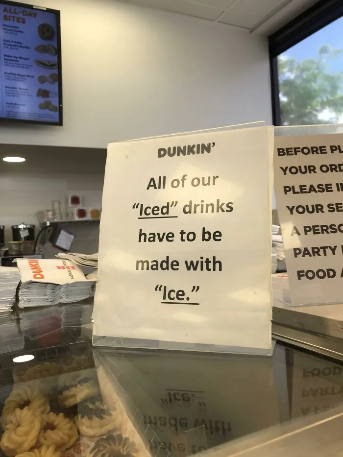 Dunkin Donuts counter sign displaying misused quotation marks around iced and ice.