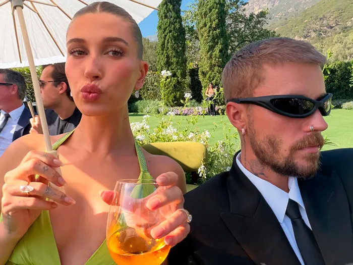 Hailey and Justin Bieber attending an outdoor event as fashionable celebs wedding guests.