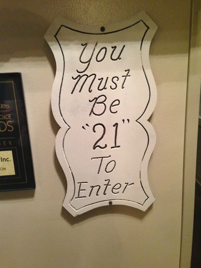 White sign with misused quotation marks around the number 21 reading You Must Be 21 To Enter.