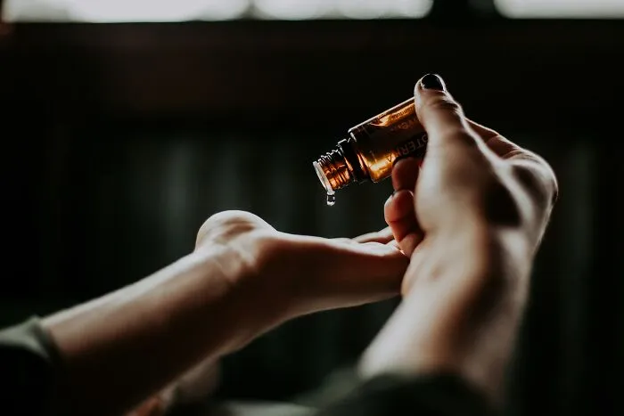 Dropping essential oil onto hand for practical life hacks use