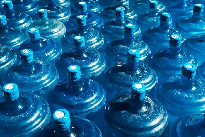 Rows of large blue water jug tops, illustrating unexpected situations in Airbnb stories.