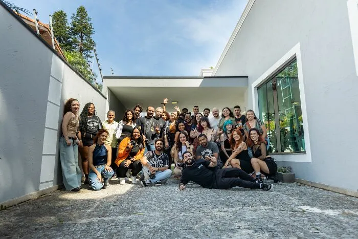 A large group of people posing together outside a rental home for crazy Airbnb stories