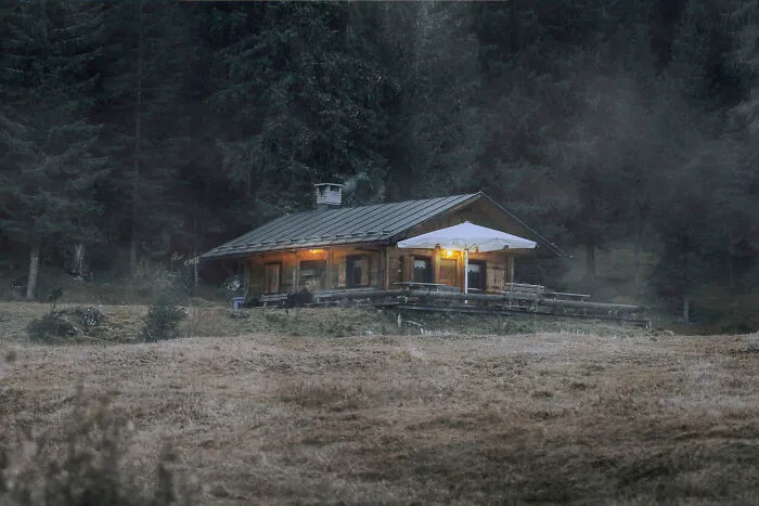 An isolated cabin in dark woods, illustrating spooky things people experienced outdoors.