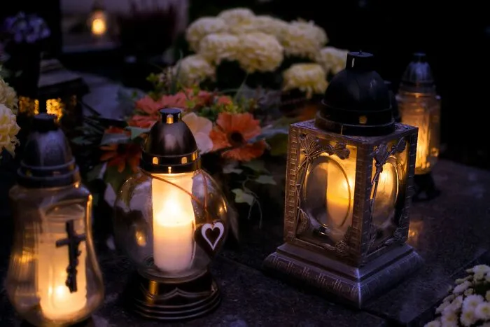 Lit candles in ornate lanterns surrounded by flowers creepy stories