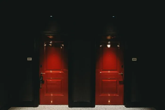 Red dimly lit doors in dark hallway creepy stories