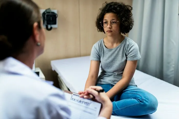 Teen girl consulting doctor looking worried about Karen impact