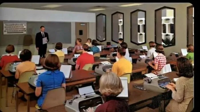Vintage classroom with students on typewriters, recalling nostalgic photos from retro school days.