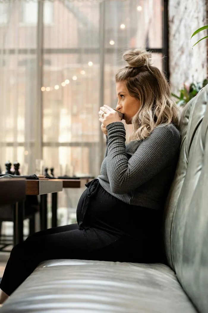 Pregnant woman drinking coffee indoors, illustrating personal rants shared online.
