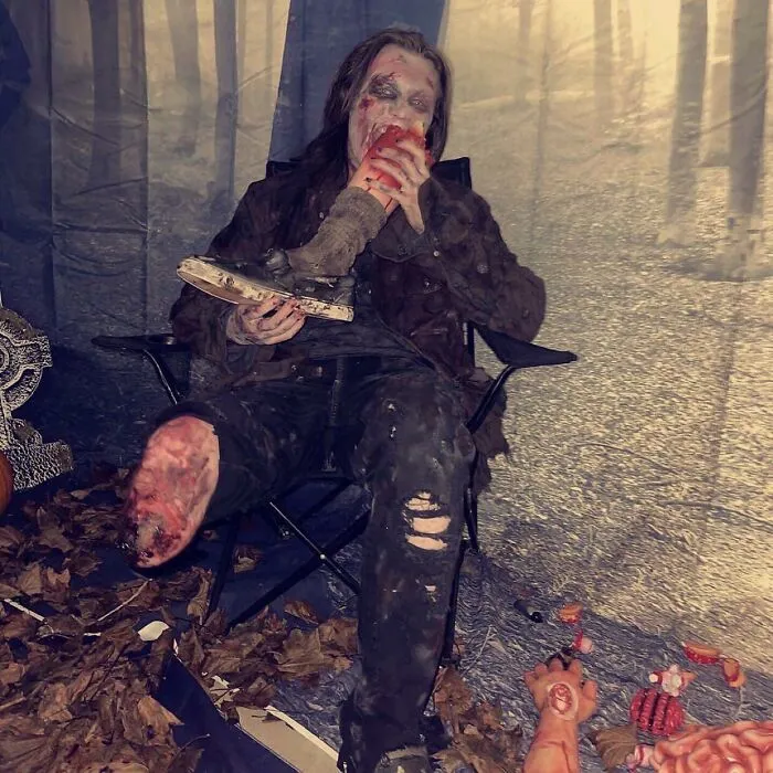 Person with a leg disability wearing a zombie costume eating a prosthetic leg for a hilarious Halloween idea.