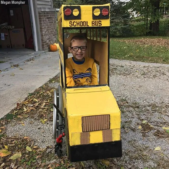 A child in a wheelchair styled as a yellow school bus for creative people with disabilities on Halloween.
