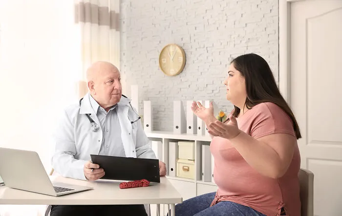 Doctor listening to frustrated woman in medical office