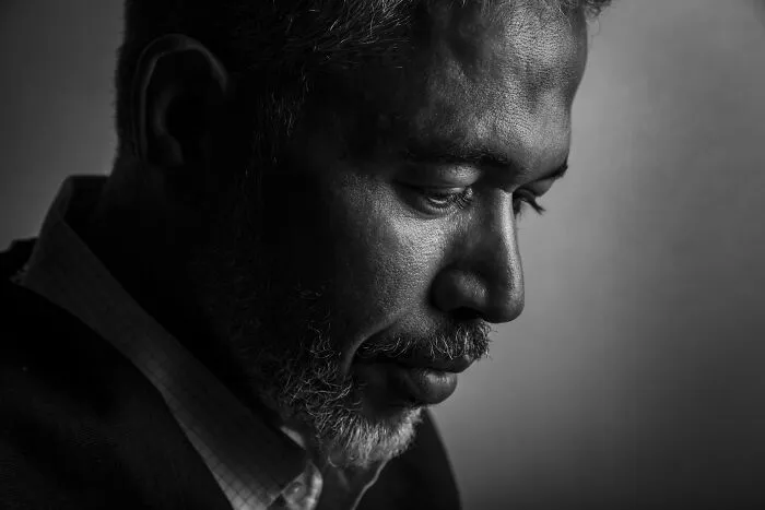 Black and white profile of a man with a beard deep in thought