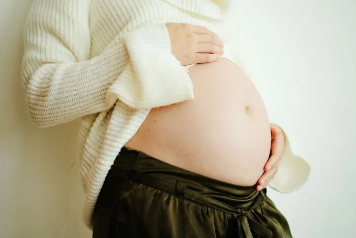 A close-up of a pregnant belly, highlighting common myths about women's bodies.