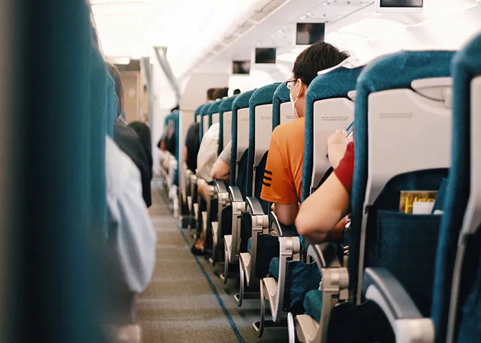 Passengers seated inside airplane cabin during flight
