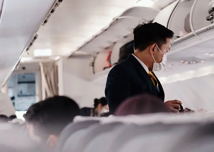 Flight attendant serving passengers on airplane at 30000 feet