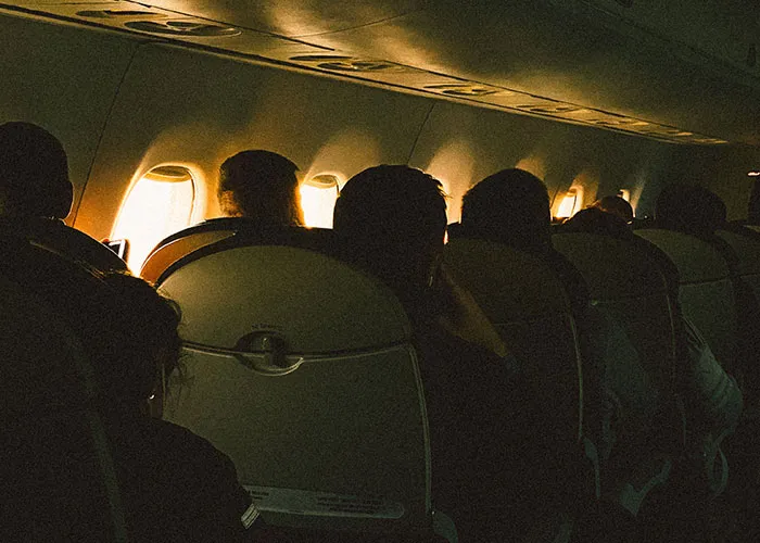 Passengers seated inside airplane cabin during flight