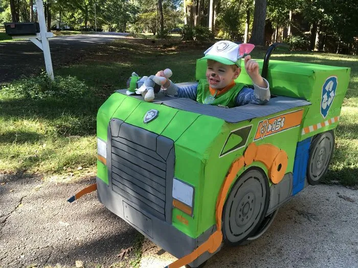 Young boy in a custom Paw Patrol truck costume for people with disabilities celebrating Halloween.