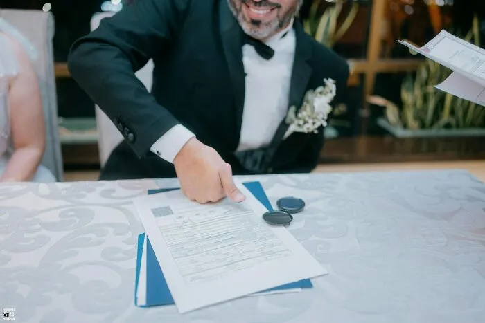 A groom signing marriage documents, avoiding unhinged relationship fights
