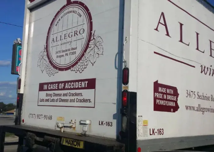 Allegro winery truck with funny accident sign asking for cheese, showing truckers turning vehicles into moving jokes