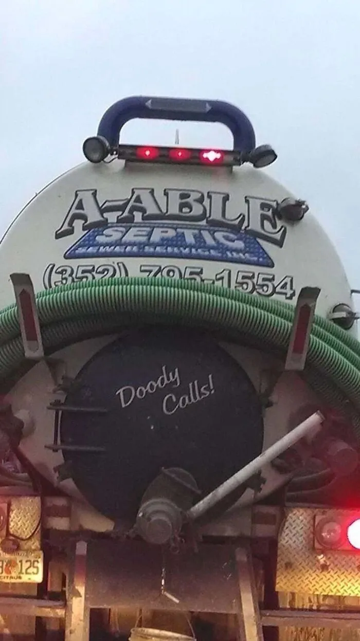 Back of a septic truck with funny text Doody Calls showcasing how truckers turn vehicles into giant moving jokes
