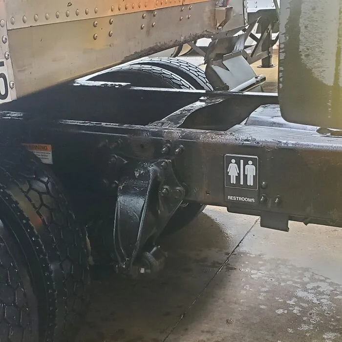 A restroom sign placed on a semi truck chassis, demonstrating creative truckers humor.