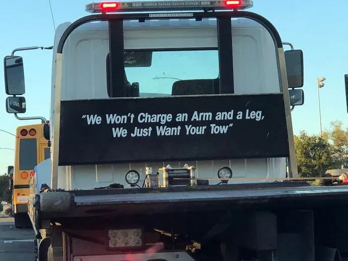 Flatbed tow truck featuring funny rhyme text printed on the headache rack.