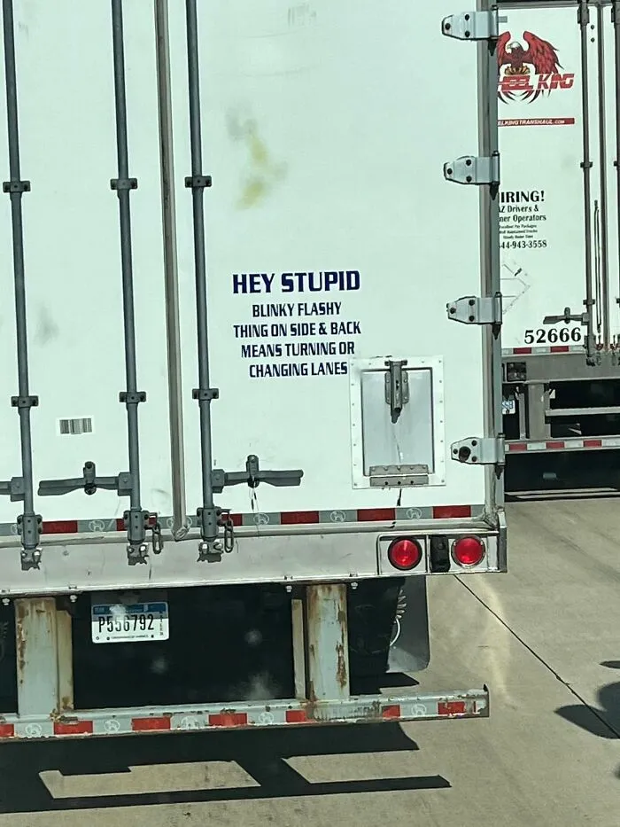 A white truck trailer with a sarcastic note about turn signals, representing humorous truckers message.