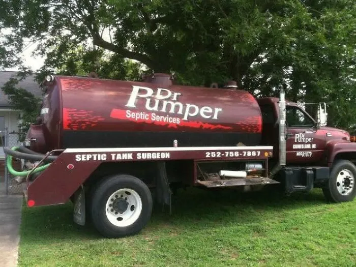 A septic service truck with humorous branding labeled Dr Pumper Septic Tank Surgeon parked on grass.