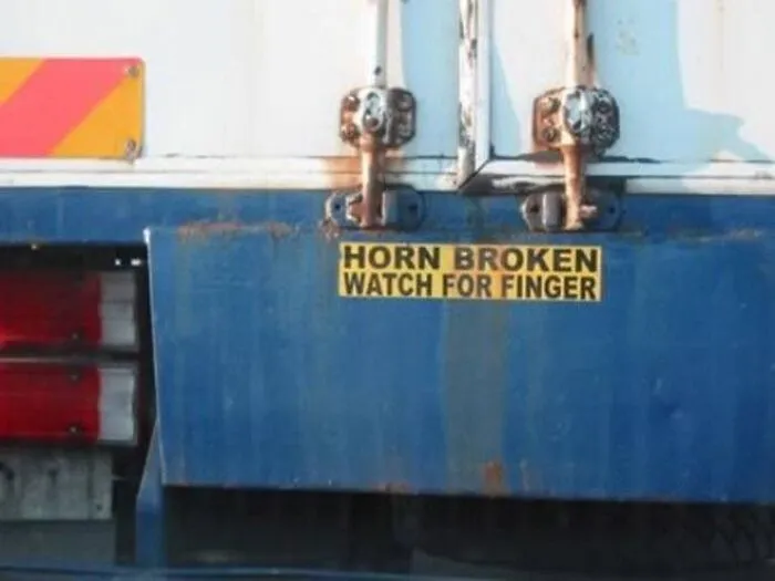 A sign reading Horn Broken Watch For Finger on a vehicle, showing funny trucker jokes.