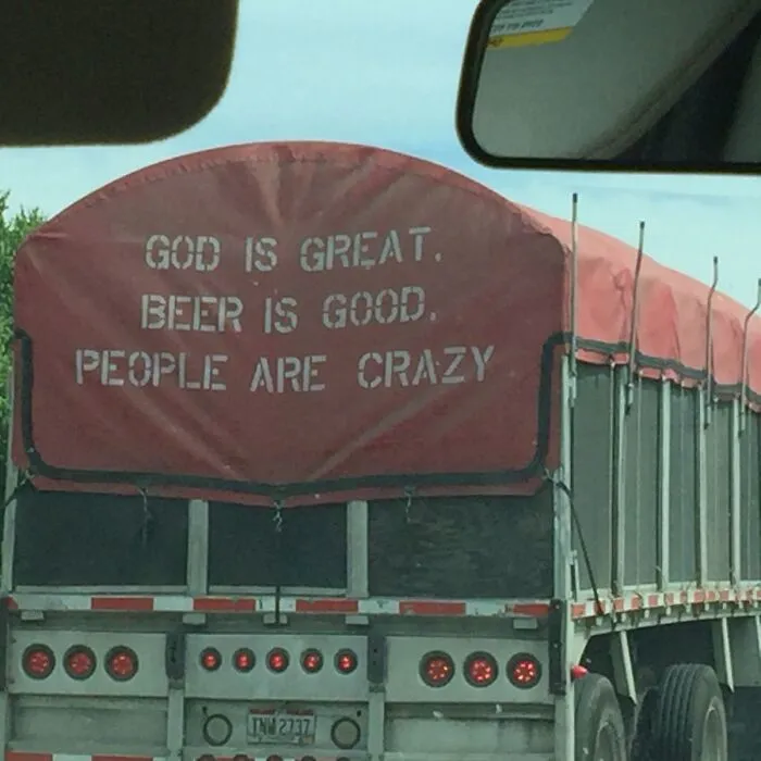 Red truck cover featuring a funny country song lyric printed in bold white text