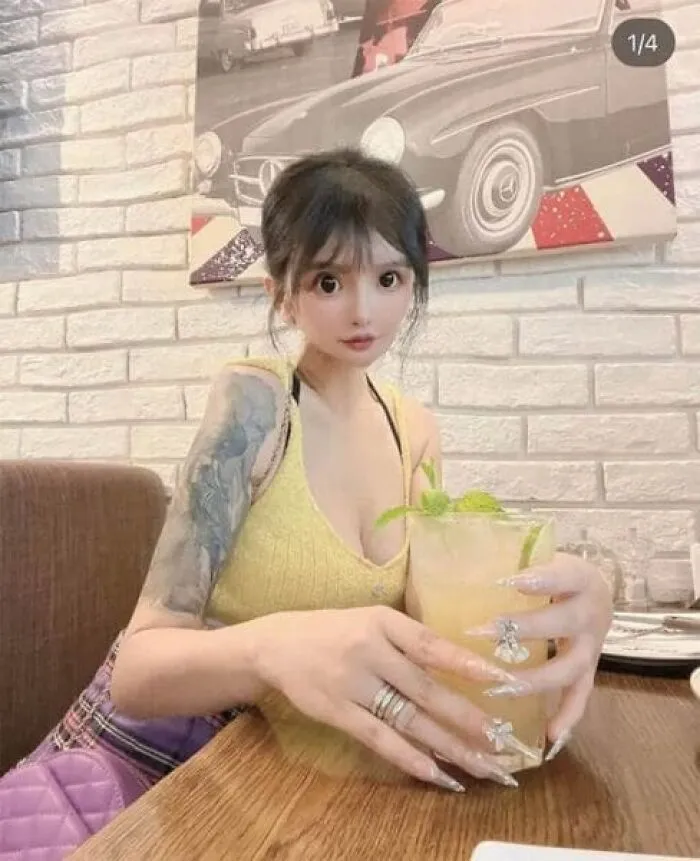 Ridiculous edited photo of woman with distorted large eyes holding a drink