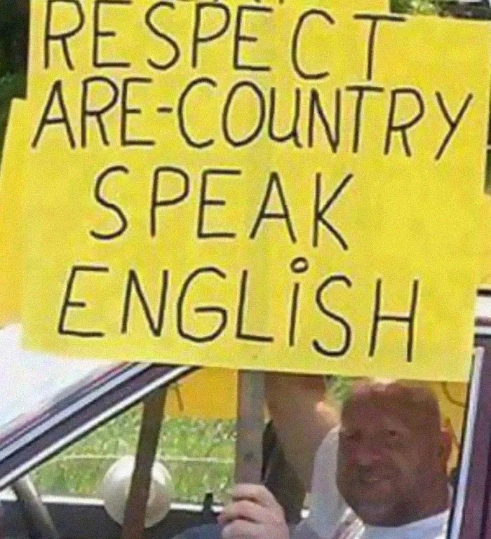 Protest sign with spelling errors demanding English, an example of someone being confidently wrong