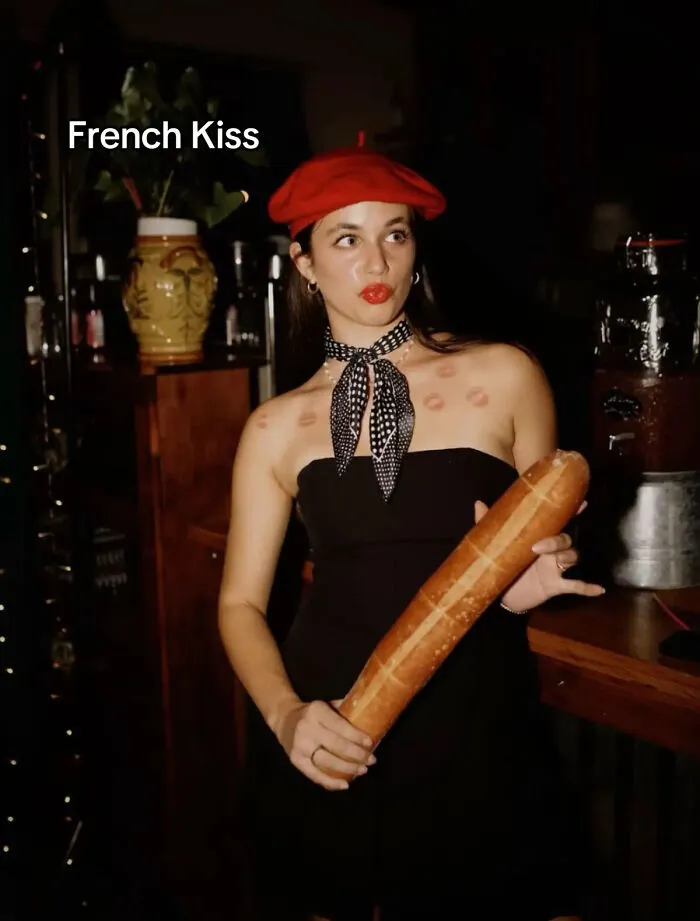 Woman dressed as French Kiss for a clever Halloween costume idea holding a baguette