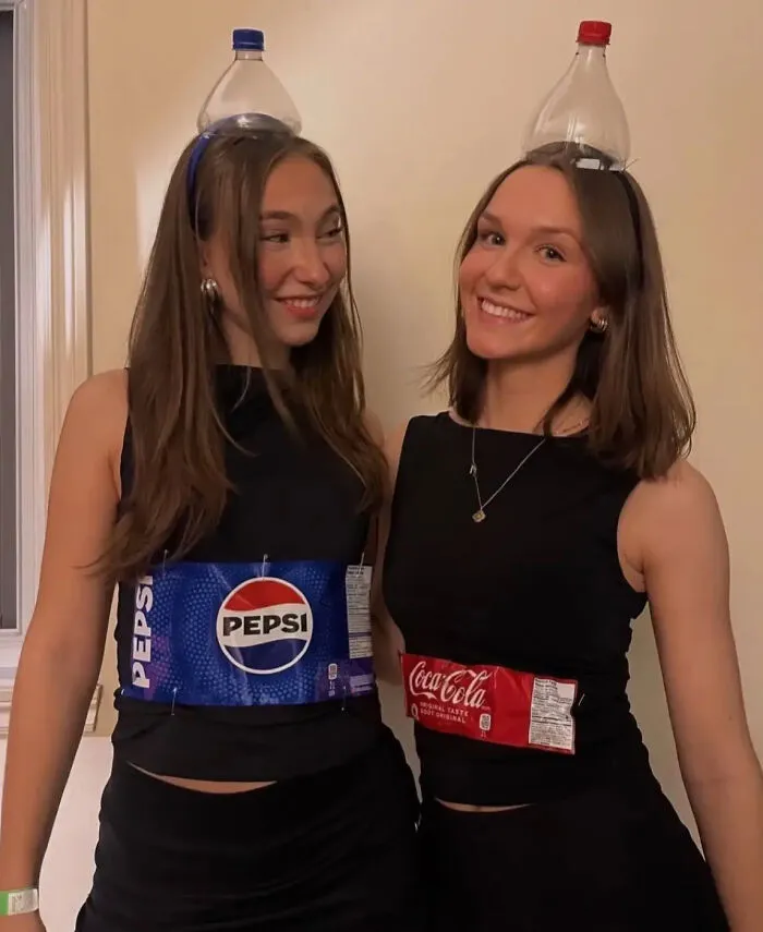 Two women wearing Pepsi and Coca-Cola bottle labels as a fun Halloween costume idea
