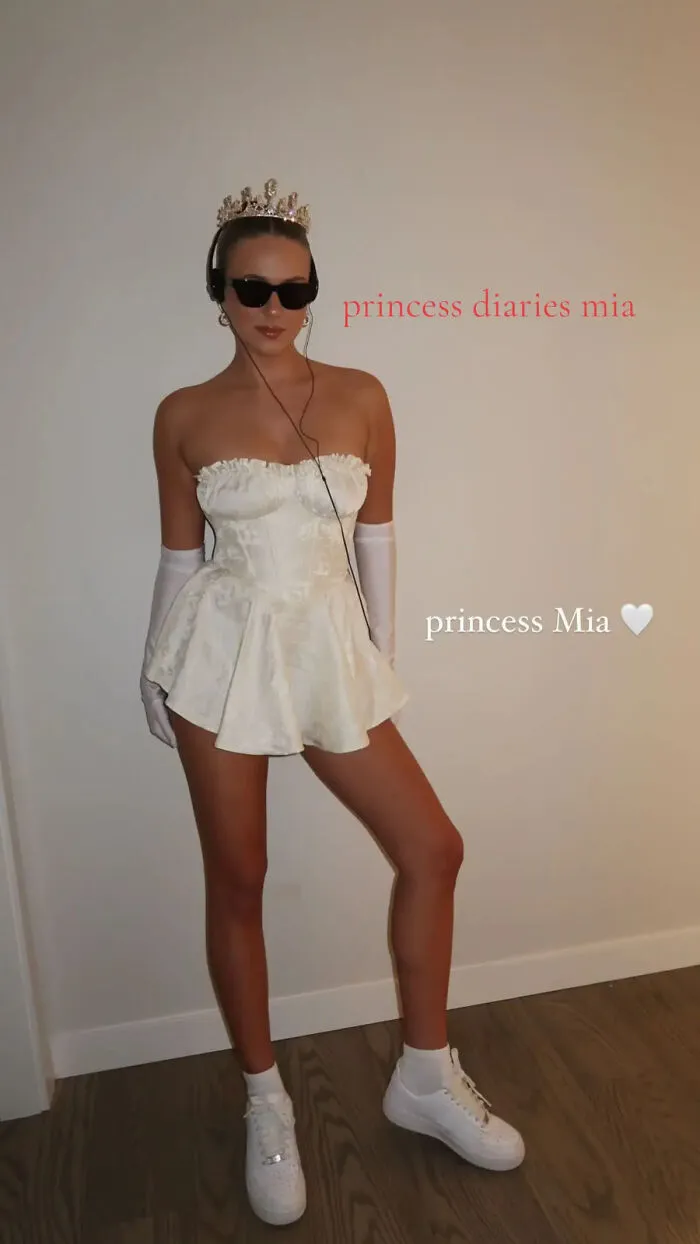 A woman wearing a tiara, sunglasses, and white dress for last minute Halloween costume ideas.