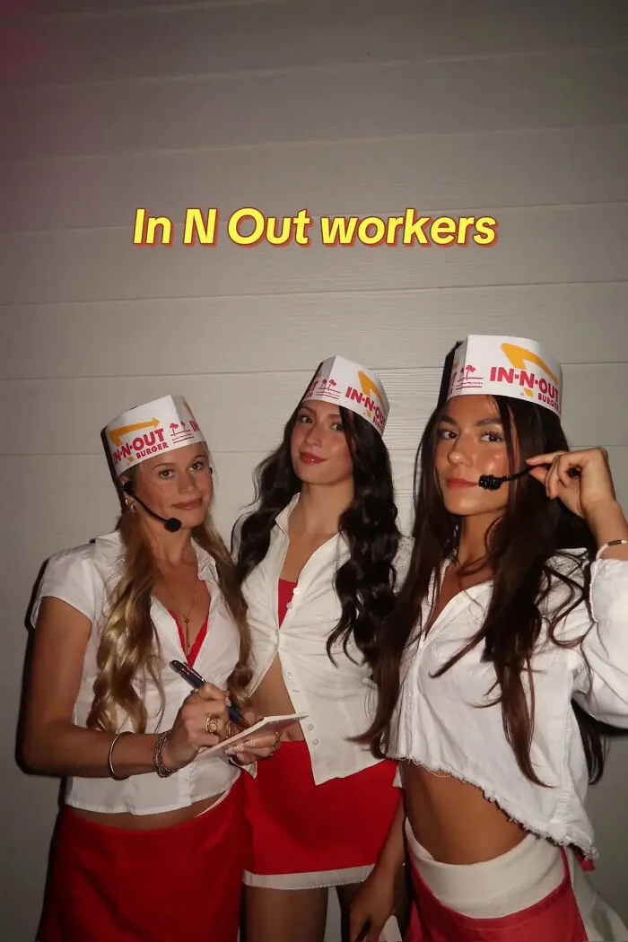 Three friends dressed in paper hats and red aprons as In-N-Out workers for a last-minute Halloween costume.