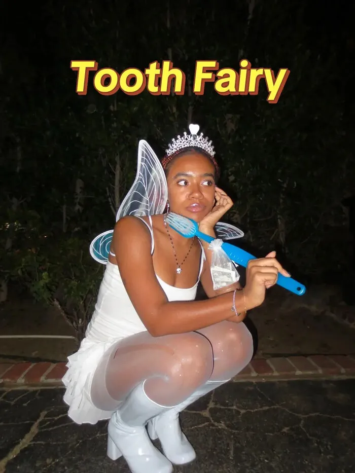 Woman dressed as the Tooth Fairy holding a giant toothbrush for creative Halloween costume ideas.