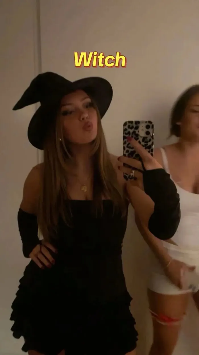A woman wearing a black pointy witch hat as a simple Halloween costume idea