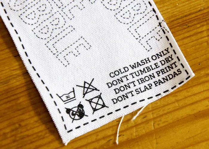 Fabric tag displaying funny and confusing labels and instructions including DON'T SLAP PANDAS.
