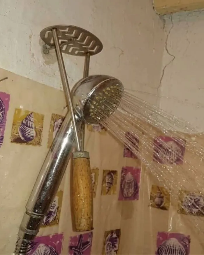 A kitchen utensil used to prop up a showerhead, an example of unusual Slavic engineering.