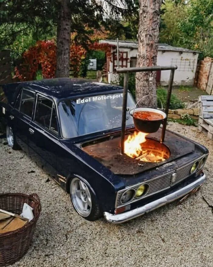 Car hood converted into an outdoor fire pit and cooking stove showing unhinged Slavic engineering.