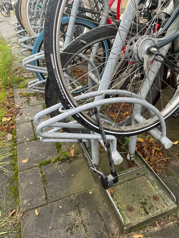 Absurd moment showing a bicycle lock secured only to a bike rack without the bike