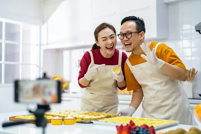 Cheerful couple filming a baking video, contrasting with infuriating things reported by people.