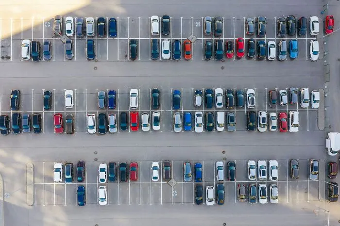 Aerial view of a full parking lot representing drama in tiny communities
