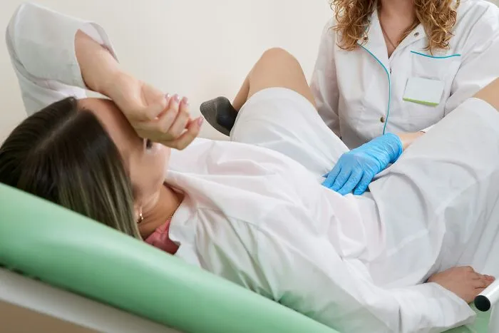 Female patient undergoing gynecological exam by medical professional
