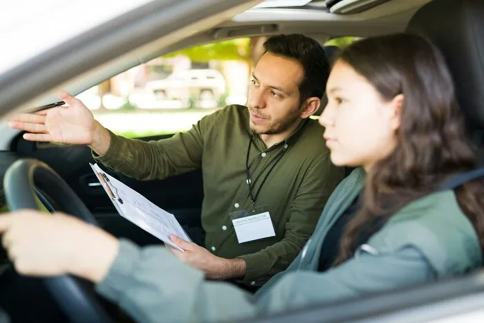 A driving instructor giving a lesson to a student, illustrating how professionals lose trust.