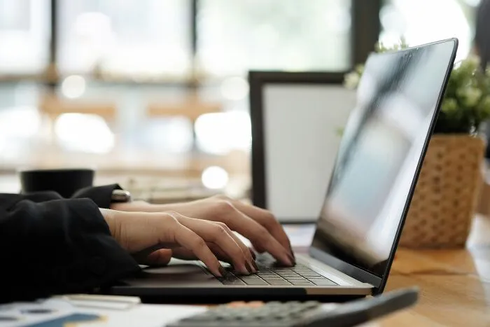 A person typing on a laptop, representing digital marketing strategies for PR stunts.